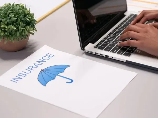 Insurance document beside a laptop