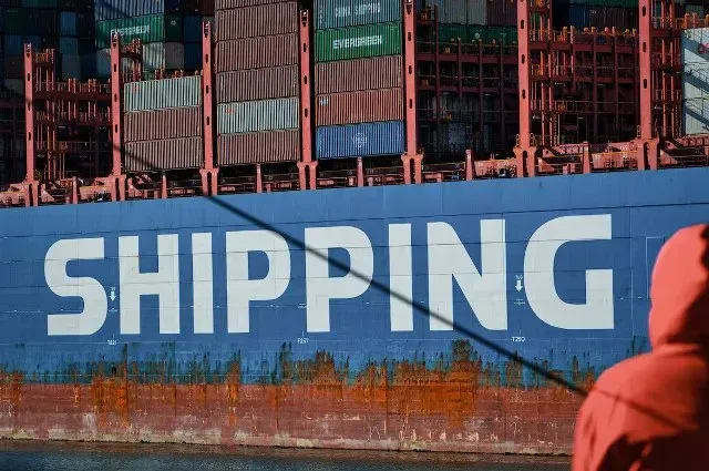 Container ship with Shipping painted on its hull