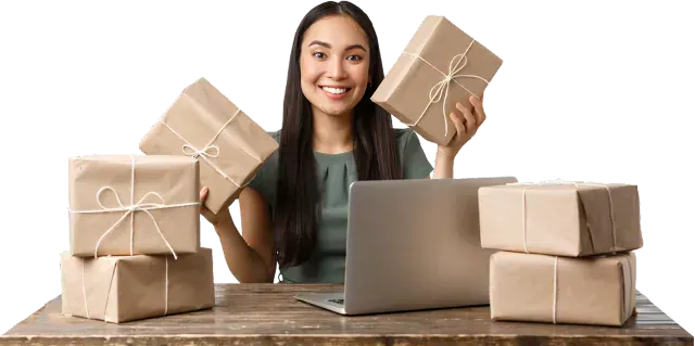 Online seller holding wrapped parcels behind a laptop