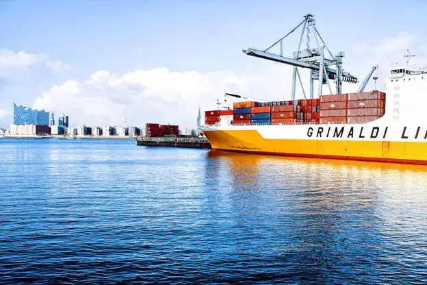 Cargo ship docked beside container cranes at a port