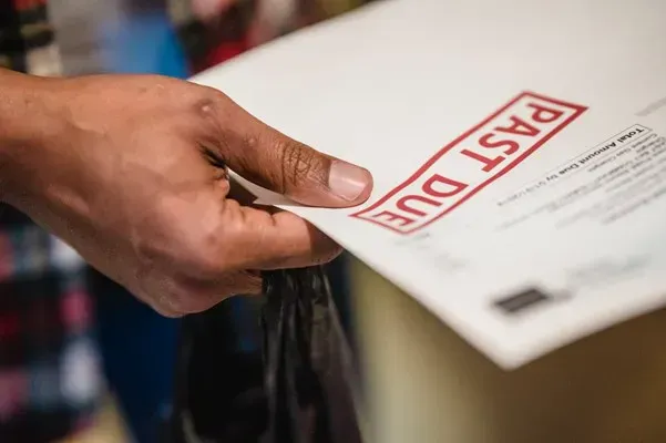Person holding an invoice stamped Past Due
