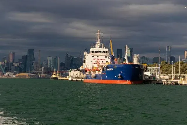 Cargo ship docked near a city skyline